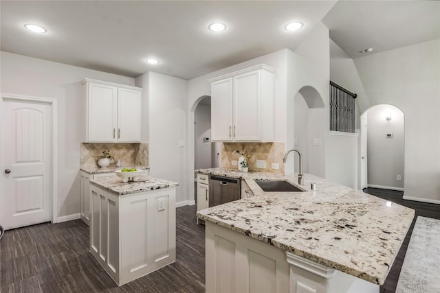 18723 Pilot Knolls Dr, Cypress, TX 77433 - kitchen with arched walkways, dishwasher, white cabinetry, a peninsula, and light stone countertops