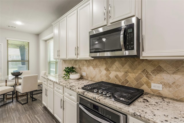 18723 Pilot Knolls Dr, Cypress, TX 77433 - kitchen featuring appliances with stainless steel finishes, white cabinetry, decorative backsplash, and light stone counters
