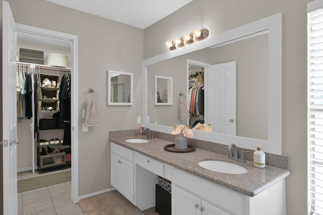 17214 Shadow Valley Dr, Spring, TX 77379 - bathroom with double vanity, a spacious closet, and tile patterned flooring