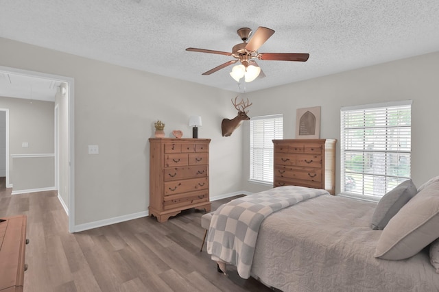 17214 Shadow Valley Dr, Spring, TX 77379 - bedroom with attic access, multiple windows, wood finished floors, and a textured ceiling