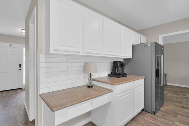 17214 Shadow Valley Dr, Spring, TX 77379 - kitchen featuring stainless steel fridge with ice dispenser, light wood-type flooring, white cabinets, and tasteful backsplash