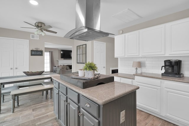 17214 Shadow Valley Dr, Spring, TX 77379 - kitchen with range hood, a center island, gray cabinetry, ceiling fan, and white cabinetry