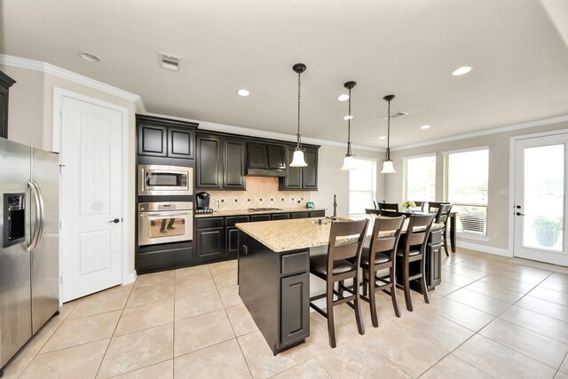 13309 Kemper Rock Ct, Rosharon, TX 77583 - kitchen with stainless steel appliances, ornamental molding, light tile patterned floors, a breakfast bar area, and decorative backsplash