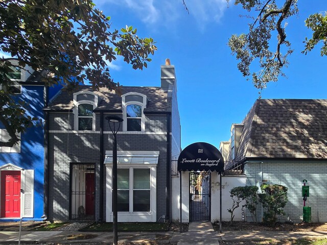 811 Lovett Blvd Unit 25, Houston, TX 77006 - view of front of house with brick siding, a gate, and a chimney