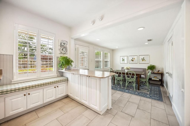2031 Cheshire Ln, Houston, TX 77018 - kitchen featuring plenty of natural light, light stone countertops, a peninsula, light tile patterned floors, and recessed lighting
