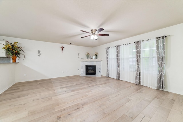 3530 Barkers Crossing Ave, Houston, TX 77084 - unfurnished living room with light wood-type flooring, a ceiling fan, and a fireplace with flush hearth
