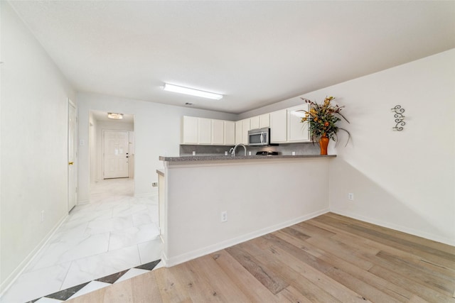 3530 Barkers Crossing Ave, Houston, TX 77084 - kitchen featuring stainless steel microwave, white cabinets, and a peninsula