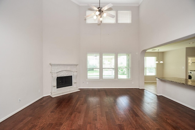 5506 Plumero Meadow Dr, Katy, TX 77494 - unfurnished living room with a towering ceiling, ceiling fan, crown molding, plenty of natural light, and a premium fireplace