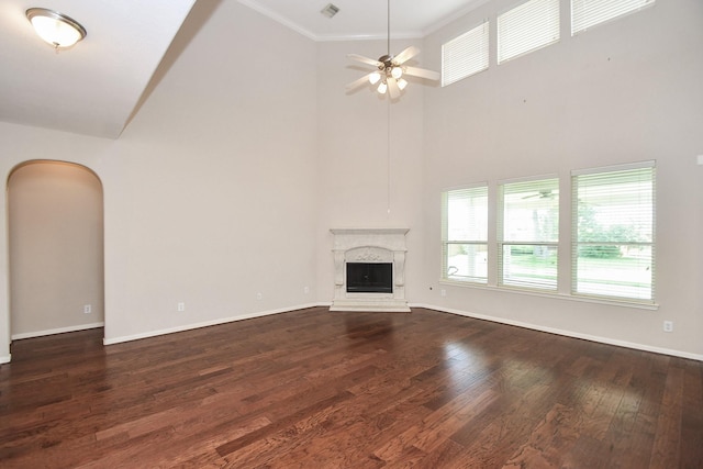5506 Plumero Meadow Dr, Katy, TX 77494 - unfurnished living room with a high ceiling, dark wood-style flooring, a ceiling fan, a premium fireplace, and arched walkways