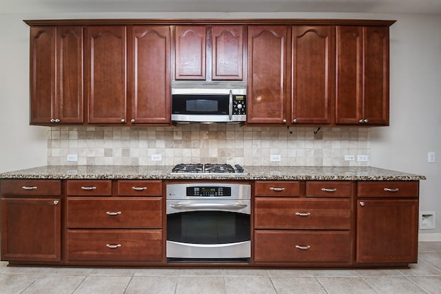 5506 Plumero Meadow Dr, Katy, TX 77494 - kitchen featuring appliances with stainless steel finishes, light stone counters, backsplash, and light tile patterned flooring