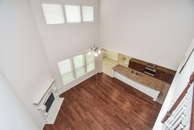 5506 Plumero Meadow Dr, Katy, TX 77494 - unfurnished living room featuring a fireplace, a ceiling fan, and dark wood-type flooring