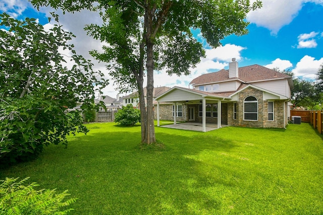 5506 Plumero Meadow Dr, Katy, TX 77494 - rear view of house featuring a ceiling fan, a fenced backyard, a chimney, a patio, and stone siding