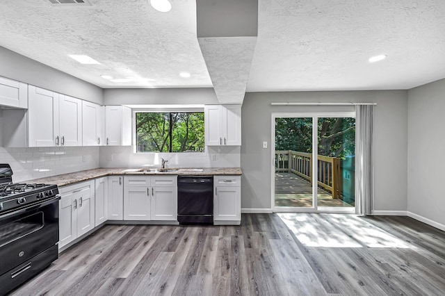 8426 Laurel Trails Dr, Houston, TX 77095 - kitchen featuring black appliances, a textured ceiling, wood finished floors, white cabinets, and tasteful backsplash