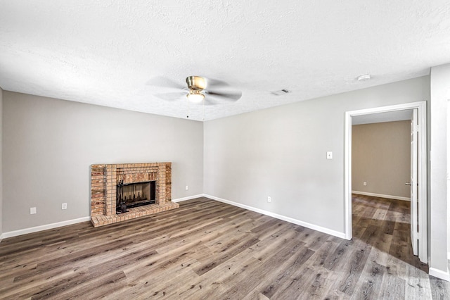 8426 Laurel Trails Dr, Houston, TX 77095 - unfurnished living room with a ceiling fan, wood finished floors, a textured ceiling, and a brick fireplace