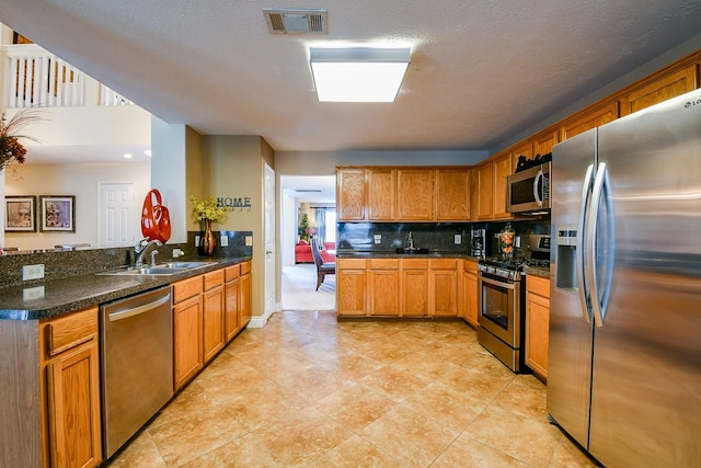 18303 June Forest Dr, Humble, TX 77346 - kitchen featuring appliances with stainless steel finishes, a peninsula, decorative backsplash, brown cabinets, and light tile patterned flooring
