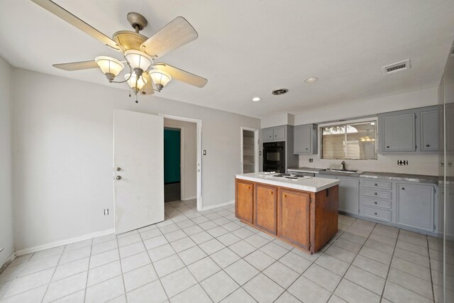 10803 Shawnbrook Dr, Houston, TX 77071 - kitchen featuring gray cabinetry, a center island, light countertops, light tile patterned flooring, and recessed lighting