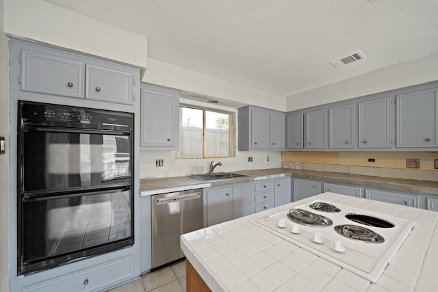 10803 Shawnbrook Dr, Houston, TX 77071 - kitchen featuring dishwasher, white electric cooktop, gray cabinets, tile countertops, and light tile patterned floors