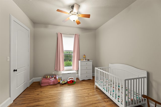27514 Siandra Creek Ln, Spring, TX 77386 - bedroom with wood finished floors, a nursery area, and a ceiling fan