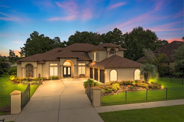 27514 Siandra Creek Ln, Spring, TX 77386 - mediterranean / spanish-style home with stucco siding, french doors, an attached garage, driveway, and a fenced front yard