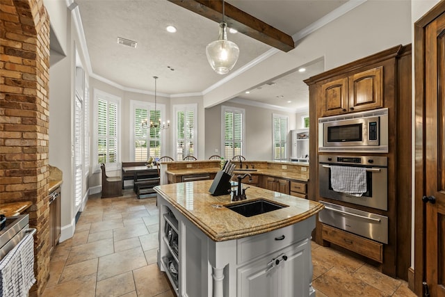 27514 Siandra Creek Ln, Spring, TX 77386 - kitchen with appliances with stainless steel finishes, a warming drawer, stone tile flooring, a kitchen island with sink, and a peninsula
