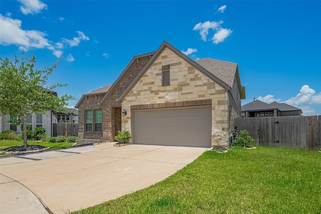 7702 Kenora Way, Richmond, TX 77407 - french country home with an attached garage, concrete driveway, stone siding, and brick siding