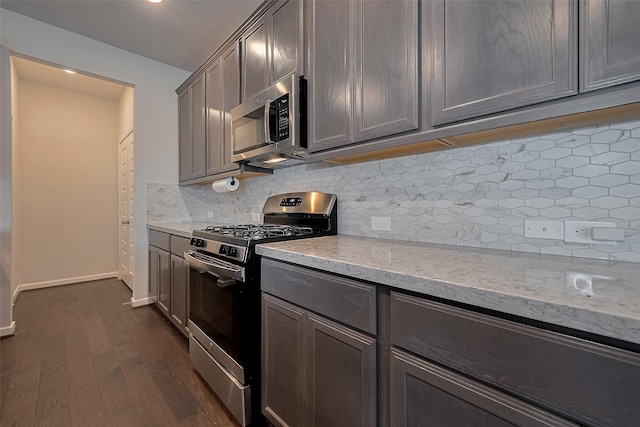 7702 Kenora Way, Richmond, TX 77407 - kitchen featuring stainless steel appliances, dark wood-type flooring, decorative backsplash, light stone counters, and gray cabinetry