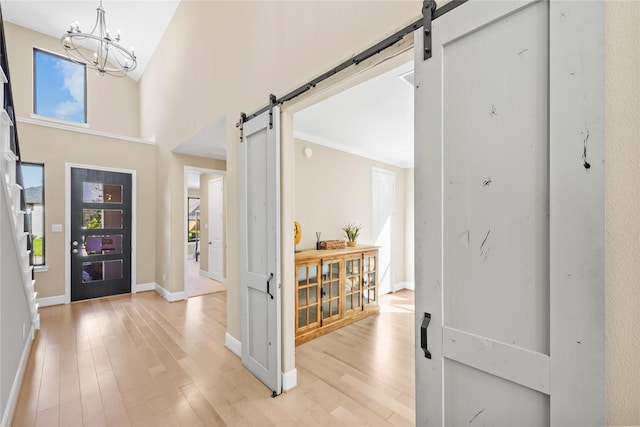 21726 Grayson Highlands Way, Porter, TX 77365 - foyer featuring a barn door, light wood-style floors, and a chandelier