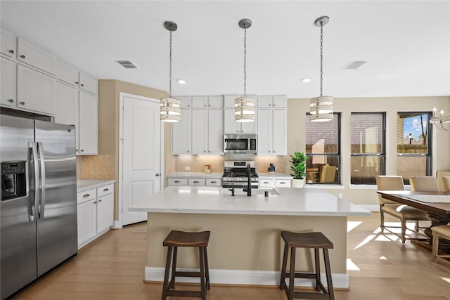 21726 Grayson Highlands Way, Porter, TX 77365 - kitchen with appliances with stainless steel finishes, light wood finished floors, decorative backsplash, light countertops, and recessed lighting