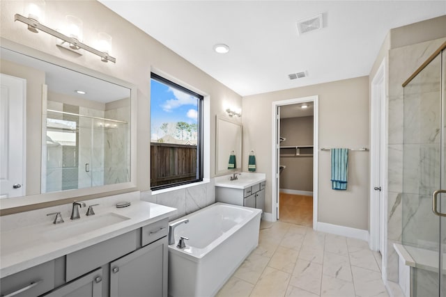 21726 Grayson Highlands Way, Porter, TX 77365 - bathroom with a stall shower, two vanities, marble finish flooring, a bathtub, and recessed lighting