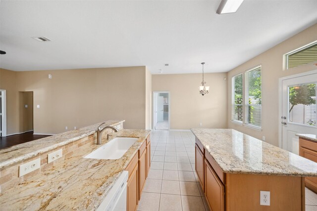 2207 Highland Hills Dr, Conroe, TX 77304 - kitchen featuring light tile patterned floors, a chandelier, a center island, and light stone countertops