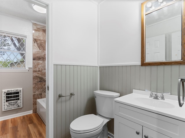 1705 Spruce St, Bay City, TX 77414 - full bath featuring heating unit, vanity, wood finished floors, a wainscoted wall, and bathing tub / shower combination