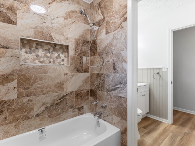 1705 Spruce St, Bay City, TX 77414 - bathroom featuring wood finished floors, bathtub / shower combination, vanity, and a wainscoted wall
