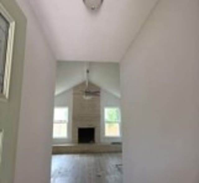 6402 Green Top Dr, San Antonio, TX 78233 - unfurnished living room with vaulted ceiling, wood finished floors, and a fireplace
