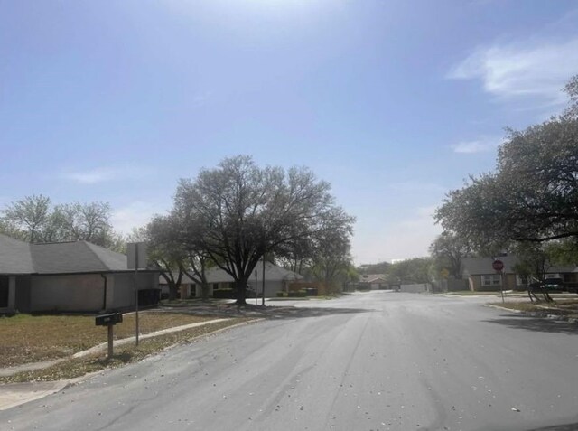 6402 Green Top Dr, San Antonio, TX 78233 - view of asphalt road featuring sidewalks, traffic signs, curbs, and a residential view