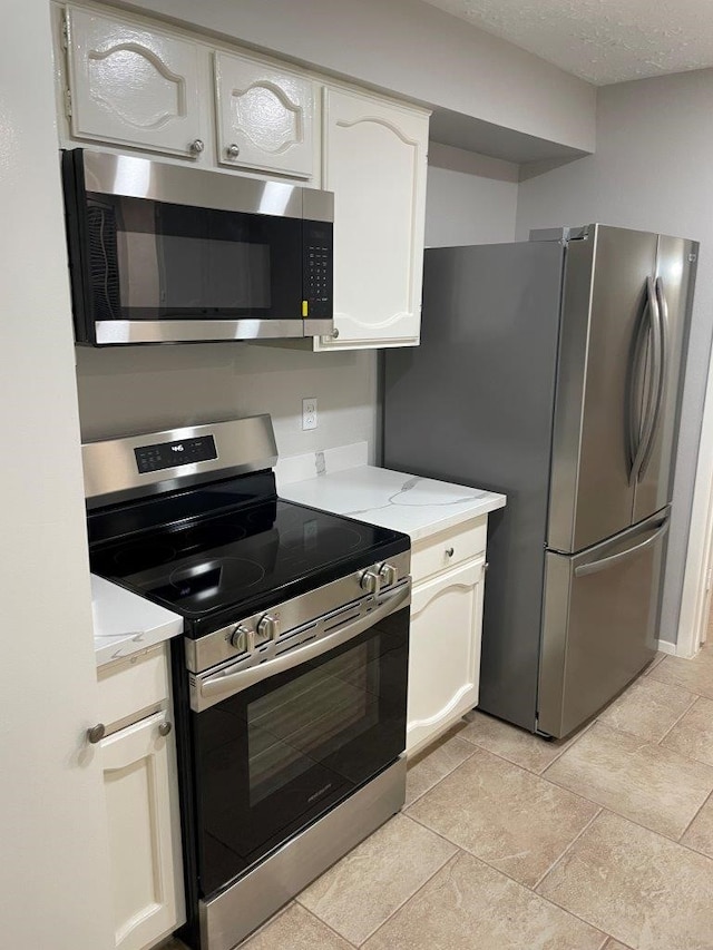 14207 Montaigne Dr, Cypress, TX 77429 - kitchen with appliances with stainless steel finishes, light stone countertops, white cabinets, and a textured ceiling