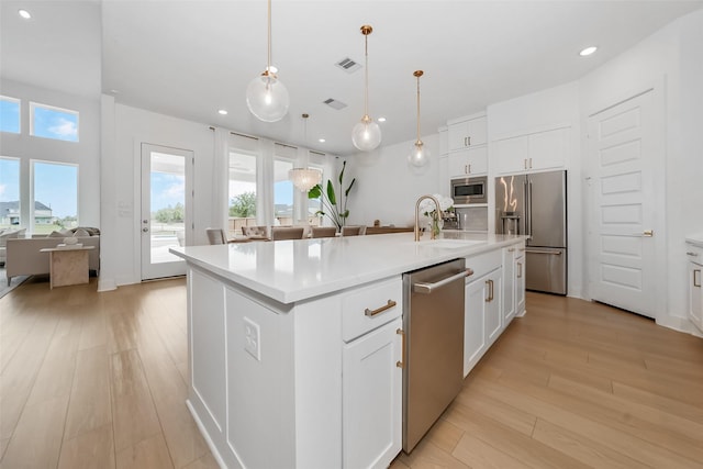 400 Horizon Light Ln, Katy, TX 77493 - kitchen with appliances with stainless steel finishes, recessed lighting, light wood-style floors, light countertops, and a center island with sink
