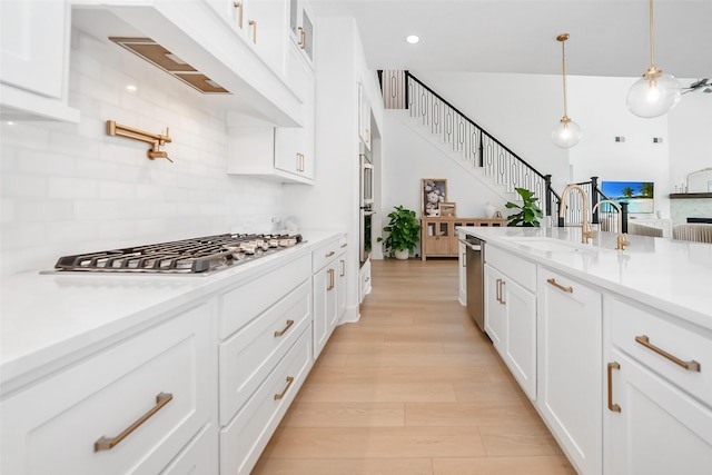 400 Horizon Light Ln, Katy, TX 77493 - kitchen featuring stainless steel appliances, tasteful backsplash, white cabinetry, light countertops, and hanging light fixtures