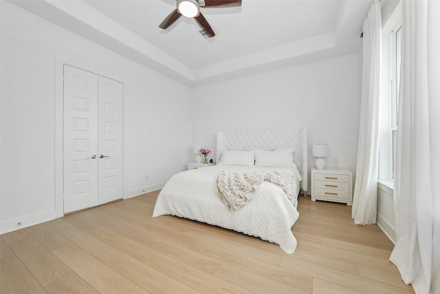 400 Horizon Light Ln, Katy, TX 77493 - bedroom featuring a raised ceiling, light wood-style floors, ceiling fan, and a closet