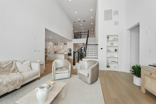400 Horizon Light Ln, Katy, TX 77493 - living room featuring a high ceiling, light wood finished floors, stairway, built in features, and recessed lighting