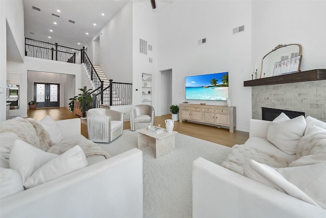 400 Horizon Light Ln, Katy, TX 77493 - living area featuring a high ceiling, wood finished floors, stairs, recessed lighting, and a fireplace