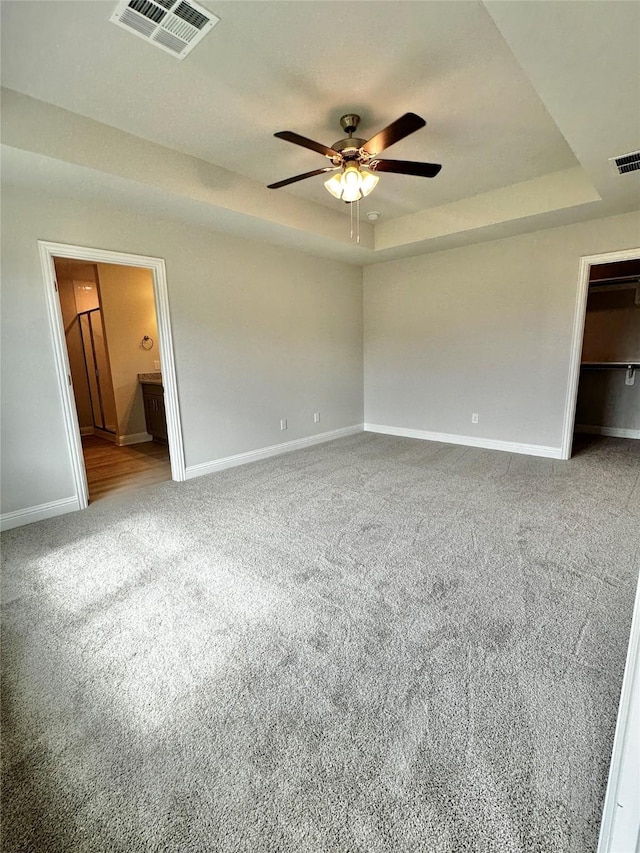 4301 Fenwick Rd, Texas City, TX 77591 - unfurnished bedroom with a raised ceiling, carpet flooring, ensuite bathroom, and a walk in closet