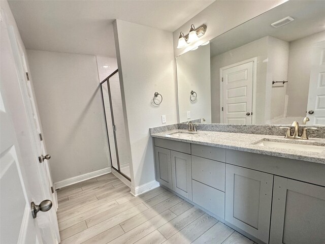 4301 Fenwick Rd, Texas City, TX 77591 - full bathroom with a stall shower, wood finished floors, and double vanity