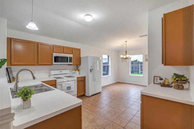 20806 Dewberry Creek Ln, Katy, TX 77449 - kitchen featuring white appliances, a chandelier, light countertops, brown cabinetry, and light tile patterned floors
