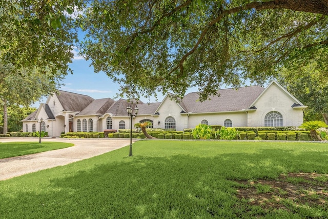 16919 Storybrook Forest Dr, Tomball, TX 77377 - french country home featuring a front lawn and curved driveway