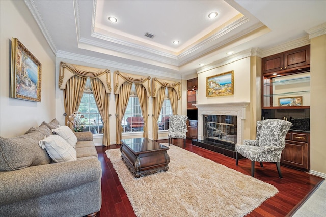 16919 Storybrook Forest Dr, Tomball, TX 77377 - living room with ornamental molding, a glass covered fireplace, dark wood-type flooring, a raised ceiling, and recessed lighting
