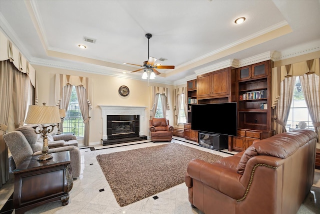 16919 Storybrook Forest Dr, Tomball, TX 77377 - living area with a tray ceiling, ornamental molding, a ceiling fan, a glass covered fireplace, and recessed lighting
