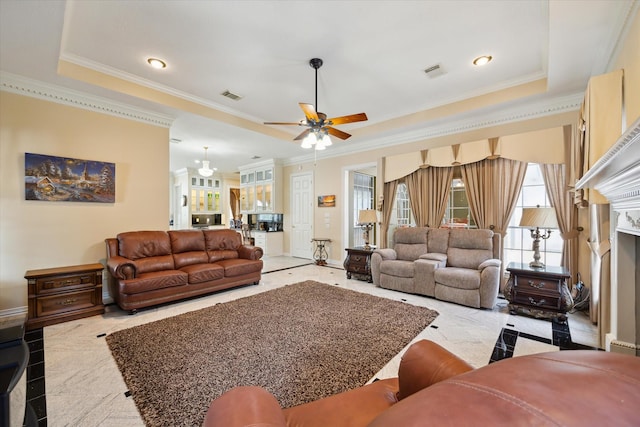 16919 Storybrook Forest Dr, Tomball, TX 77377 - living area with inlaid floor details, crown molding, a ceiling fan, a tray ceiling, and a fireplace