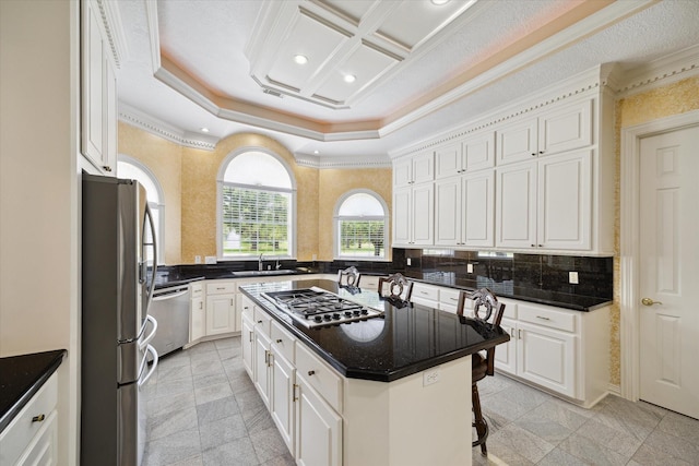 16919 Storybrook Forest Dr, Tomball, TX 77377 - kitchen with stainless steel appliances, a breakfast bar, white cabinetry, a center island, and ornamental molding