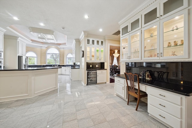 16919 Storybrook Forest Dr, Tomball, TX 77377 - kitchen with freestanding refrigerator, wine cooler, dark countertops, crown molding, and built in desk