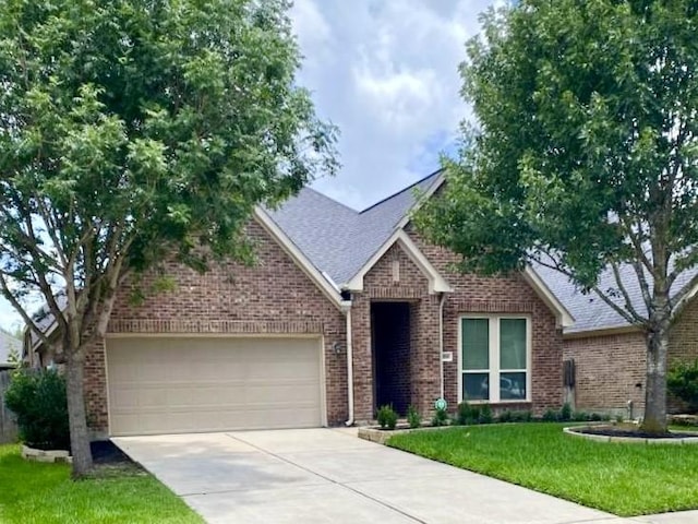 29018 Pinnacle Ridge Dr, Katy, TX 77494 - view of front of home with concrete driveway, an attached garage, brick siding, a front yard, and roof with shingles
